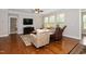 Comfortable living room with natural light, hardwood floors, and a TV at 1305 Chronicle Dr, Durham, NC 27703