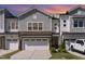 Charming townhome exterior featuring stone accents, a two-car garage, and well-maintained landscaping at 132 Deardom Way, Chapel Hill, NC 27516