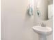 Powder room featuring a pedestal sink, round mirror, and modern fixtures at 132 Deardom Way, Chapel Hill, NC 27516