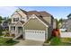 A charming two-story home with a meticulously maintained lawn and a two car garage at 1320 Abington Dr, Mebane, NC 27302