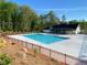 Community pool featuring a large swimming area, surrounding trees, and fence at 1320 Abington Dr, Mebane, NC 27302