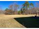 A large backyard featuring a spacious lawn with mature trees around the perimeter of the property at 1320 Double Oak Ln, Willow Springs, NC 27592