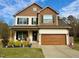 Charming two-story home with a well-manicured lawn, covered porch, and attached two-car garage at 1320 Double Oak Ln, Willow Springs, NC 27592