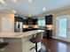 Kitchen features stainless steel appliances, dark cabinets, a breakfast bar and hardwood floors at 1320 Double Oak Ln, Willow Springs, NC 27592