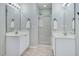Bright bathroom with double sinks, mirrors, and a glass-enclosed shower at 136 River Pearl St, Raleigh, NC 27603