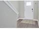 Inviting foyer with a white front door, wood-look floors, neutral wall paint and white trim at 136 River Pearl St, Raleigh, NC 27603