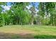Large green space with mature trees and a bench, perfect for relaxation and outdoor activities at 136 River Pearl St, Raleigh, NC 27603