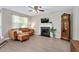 Cozy living room featuring a fireplace with decorative mantle, wood-look floors, and a brown sectional sofa at 136 River Pearl St, Raleigh, NC 27603