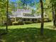 Spacious backyard with mature trees and covered porch provides a serene outdoor retreat at 1415 Meadow Wind Ln, Hillsborough, NC 27278