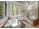 Bright bathroom featuring a soaking tub, a glass shower enclosure, and natural lighting from multiple windows at 1415 Meadow Wind Ln, Hillsborough, NC 27278