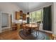 Cozy dining room with wooden table, chairs, built-in hutch, and a large window overlooking lush greenery at 1415 Meadow Wind Ln, Hillsborough, NC 27278