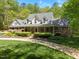 Well-manicured front lawn and mature trees provide a beautiful backdrop to the brick home at 1415 Meadow Wind Ln, Hillsborough, NC 27278