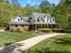 Charming brick home with covered porch and well-maintained landscaping nestled in a green environment at 1415 Meadow Wind Ln, Hillsborough, NC 27278