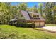 Spacious three-car garage attached to a brick home with well-maintained landscaping and a lush green lawn at 1415 Meadow Wind Ln, Hillsborough, NC 27278