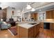 Open kitchen featuring a central island with cooktop and an adjacent living area beneath a vaulted ceiling at 1415 Meadow Wind Ln, Hillsborough, NC 27278