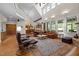 Bright living room with vaulted ceilings, hardwood floors, fireplace, and large windows with scenic views at 1415 Meadow Wind Ln, Hillsborough, NC 27278