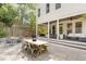 Backyard patio area with a wooden picnic table, outdoor seating, and a covered patio area at 1422 Banbury Rd, Raleigh, NC 27607