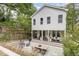 Backyard showcasing a covered porch, patio with dining area, fire pit, and lush landscaping at 1422 Banbury Rd, Raleigh, NC 27607