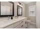 Bathroom featuring double sink vanity with quartz countertop and framed mirrors with contemporary lighting at 1422 Banbury Rd, Raleigh, NC 27607