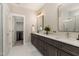 Bathroom with double sink vanity, closet, white marble floor, and modern lighting at 1422 Banbury Rd, Raleigh, NC 27607