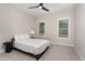 A cozy bedroom with minimalist decor, featuring a comfortable bed and natural light from two windows at 1422 Banbury Rd, Raleigh, NC 27607