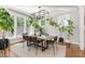 Sunlit dining room featuring large windows, a modern chandelier, and hardwood floors at 1422 Banbury Rd, Raleigh, NC 27607
