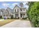 Charming two-story white home featuring a well-manicured lawn, tasteful landscaping, and a spacious driveway at 1422 Banbury Rd, Raleigh, NC 27607