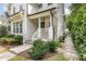 Inviting front porch with a modern railing, lush landscaping, and a concrete walkway at 1422 Banbury Rd, Raleigh, NC 27607