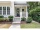 Welcoming entrance featuring a covered porch, stylish door, and manicured shrubbery at 1422 Banbury Rd, Raleigh, NC 27607