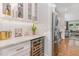 Wet bar with wine fridge, glass shelving, marble counter, and modern lighting at 1422 Banbury Rd, Raleigh, NC 27607