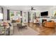 Open-concept living room featuring hardwood floors, large windows, and stylish furniture at 1422 Banbury Rd, Raleigh, NC 27607