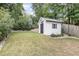 This newly built shed has white horizontal siding, a metal roof, dark trim, and a small window at 1422 Banbury Rd, Raleigh, NC 27607