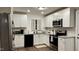 Bright kitchen featuring white cabinets, stainless steel appliances, granite countertops, and modern fixtures at 1436 Sedwick Rd, Durham, NC 27713