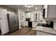 Well-lit kitchen features white cabinets, stainless steel appliances, granite countertops, and a laundry room at 1436 Sedwick Rd, Durham, NC 27713