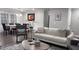 Inviting living room with a white leather sofa, chair, and wooden table, adjacent to dining area with large window at 1436 Sedwick Rd, Durham, NC 27713