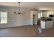 Open dining room with chandelier and wainscoting leading into bright kitchen with white cabinets and stainless appliances at 200 Green Pines Estates Dr, Kenly, NC 27542