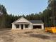 New construction home with attached garage on a spacious lot surrounded by mature trees and clear blue sky at 200 Green Pines Estates Dr, Kenly, NC 27542