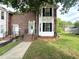 Brick townhouse with a white door, black shutters, and landscaped front yard at 208B Mallard Creek Dr, Graham, NC 27253