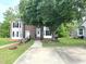 Brick townhouse with a sidewalk, large tree, and landscaped yard at 208B Mallard Creek Dr, Graham, NC 27253