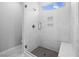 Modern tiled shower with glass door, window, bench, and tiled floor offers a luxurious feel at 2328 Beeblossom Pl, Fuquay Varina, NC 27526