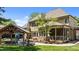 Beautiful backyard features a covered patio with outdoor seating, mature trees, and well manicured lawn at 255 Capellan St, Wake Forest, NC 27587