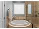 Luxurious bathroom showcasing a soaking tub, decorative window, and a seamless glass shower at 255 Capellan St, Wake Forest, NC 27587