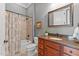Bathroom featuring a shower-tub combo, wooden vanity with granite countertop and decorative fixtures at 255 Capellan St, Wake Forest, NC 27587
