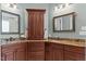 Elegant bathroom featuring double sinks, granite countertops, and a cherry-wood storage cabinet at 255 Capellan St, Wake Forest, NC 27587
