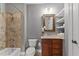 Bathroom featuring a shower-tub combo and wooden vanity with granite countertop and decorative mirror at 255 Capellan St, Wake Forest, NC 27587