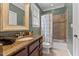 Bathroom featuring a shower-tub combo and wooden vanity with granite countertop and decorative fixtures at 255 Capellan St, Wake Forest, NC 27587