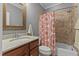 Bathroom featuring a shower-tub combo with decorative curtain, granite vanity, and a framed mirror at 255 Capellan St, Wake Forest, NC 27587