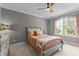 Cozy bedroom featuring a large window, ceiling fan, and stylish decor at 255 Capellan St, Wake Forest, NC 27587