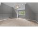 Bright bonus room with angled ceilings, plush carpet, and a large window with backyard views at 255 Capellan St, Wake Forest, NC 27587