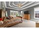 A spacious main bedroom with a tray ceiling, carpeted floors, and two large windows at 255 Capellan St, Wake Forest, NC 27587